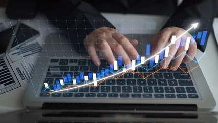 A business professional uses a laptop to analyze financial data represented by charts and graphs, showcasing growth trends and strategic insights in a modern office environment. Copula