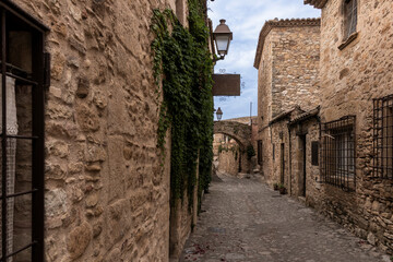Narrow cobblestone street winding through medieval peratallada, spain