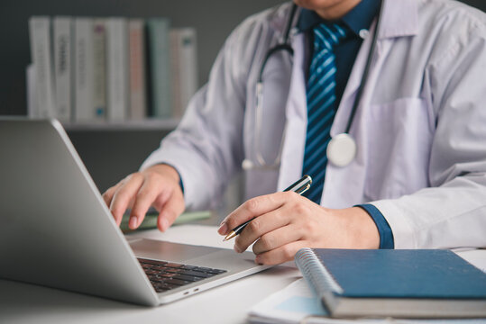 Doctor, healthcare Medical uses laptop in hospital clinic update EHR patient records and write notes, supporting accurate diagnosis and treatment stethoscope visible. concept digital care workflow.