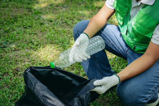 Environmental volunteer collects plastic bottle for recycling cleanup drive promoting green initiatives in nature - Powered by Adobe