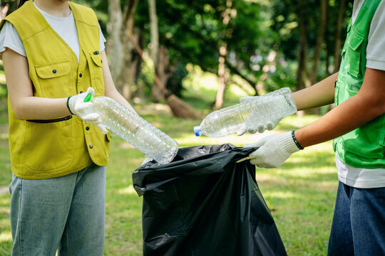Dedicated volunteers collect plastic bottles for recycling in a public park promoting environmental sustainability community action