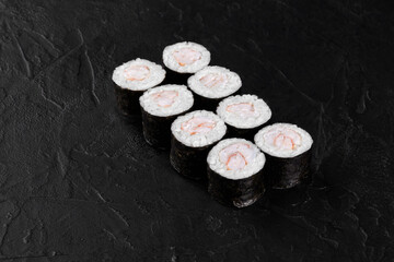 Eight shrimp sushi rolls presenting on dark background