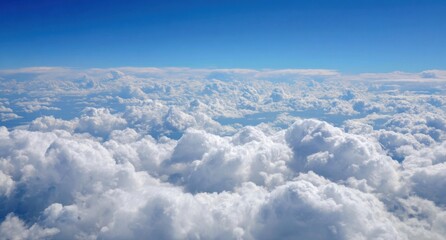 A vast expanse of fluffy white clouds against a vibrant blue sky