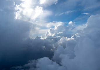Dramatic sky with sunbeams and clouds seen from an airplane