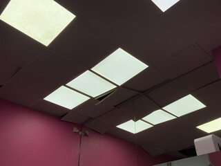 Broken suspended ceiling tiles revealing electrical wiring and insulation.mildew.brown stain,...