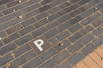 A close-up of a paved parking spot marked with a large white 