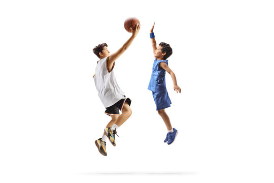 Teenage boy playing basketball with a kid