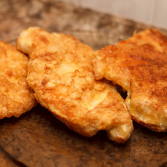 Golden fried chicken cutlets stacked on a plate. Crispy texture and appetizing appearance