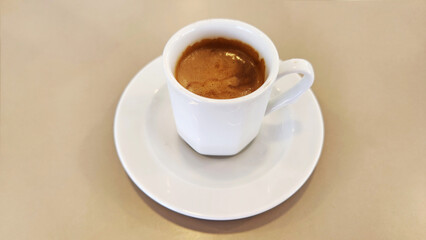 A double espresso in a white cup, with its exquisite aroma, for a morning boost