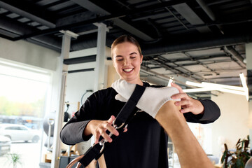 Physical therapist assisting a client with stretch exercises using equipment in a clinic