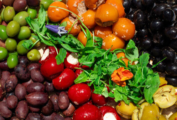 platter with assorted olives and mini stuffed sweet peppers filled with soft cheese. 
