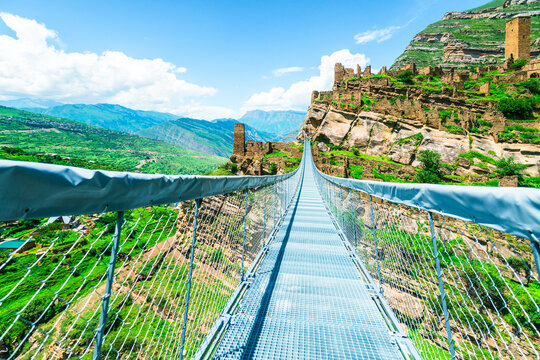 Modern mountain suspension bridge leading to the ruins of the village of Kakhib. North Caucasus - Powered by Adobe