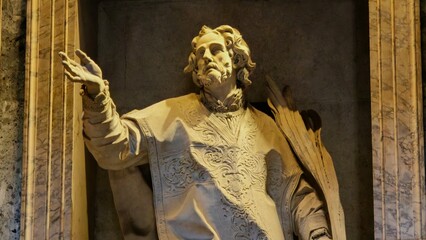 Obraz premium Rome, Italy - 10 January 2025. Statue inside the Pantheon depicting a robed male saint with raised arm and palm leaves, carved in marble and placed in a stone alcove.