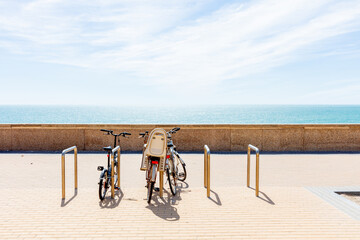 Cyclists ride along the seaside promenade with the Atlantic Ocean in view. Cadiz, Andalusia, Spain, September 2025.