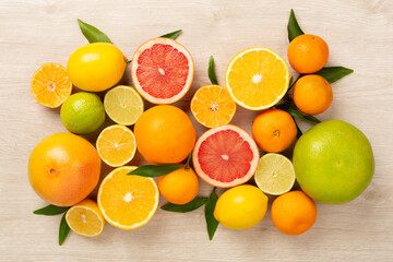 Different citrus fruits on wooden background, top view
