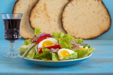 Tuna salad for Jewish holiday Pesach or Passover on blue wooden background.
