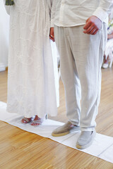 Bride and groom standing together at the aisle, bride holding bouquet of flowers, wedding attire.