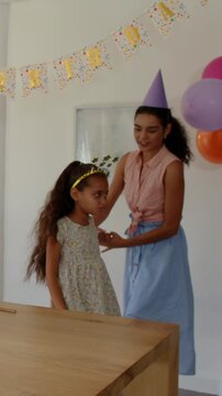 Vertical video: Mother and daughter hugging at bannered table spinning and lifting her for birthday
