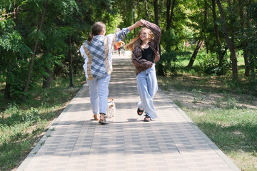 Fototapeta premium woman and her daughter walking her jack Russel terrier puppy in the city park