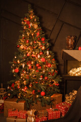 Christmas tree decorated with red and gold ornaments and lights. Festive interior for winter holiday celebration and New Year.