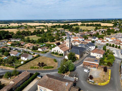 Photo a&eacute;rienne de Eglise Saint Gervais Saint Protais &agrave; Champagn&eacute;-Saint-Hilaire. Vue de la partie est de l'&eacute;glise (le choeur) et du clocher carr&eacute;. En arri&egrave;re plan les maisons du village et la campagne.