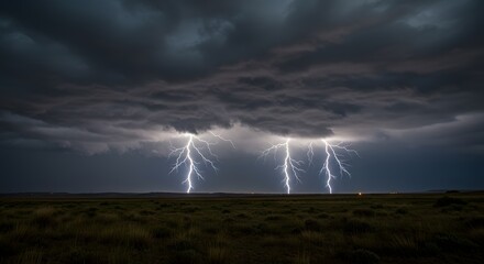 Three bolts of lightning strike the ground under a dark and stormy sky at night over a field landscape