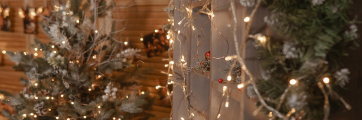 Christmas string light garland with glowing bulbs draped on a wooden pillar. Warm holiday decoration for festive interior.