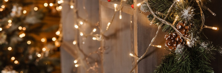 Close up of Christmas garland lights and decorative green pine branch. Holiday festive decoration...