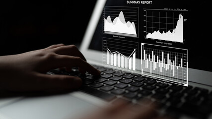 A close-up view of hands typing on a laptop keyboard with visual data analytics charts displayed on the screen, showcasing financial details and market trends. Impute