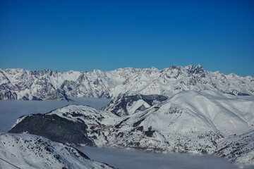 Obraz premium Panoramic alpine mountain range above a sea of clouds at midday