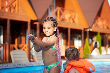 Girl playing with water at summer resort
