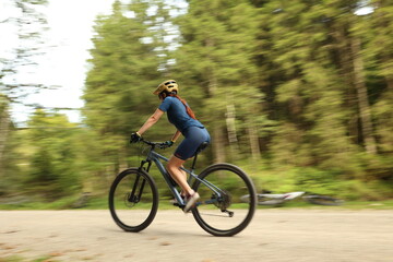 Fototapeta premium girl on a bicycle in motion in the forest