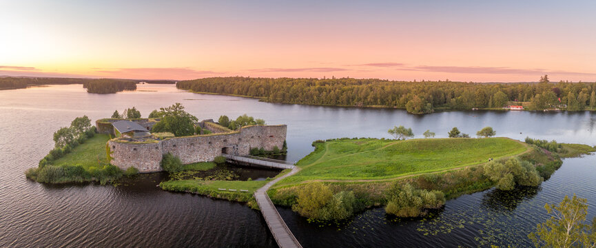 Aerial view of Kronoberg castle ruin on Helgasjön lake in Växjö Municipality in southern Småland, with dramatic sunset sky