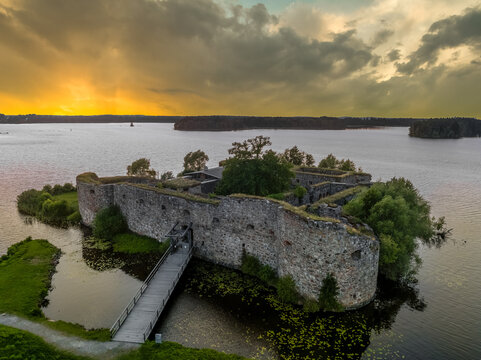 Aerial view of Kronoberg castle ruin on Helgasjön lake in Växjö Municipality in southern Småland, with dramatic sunset sky