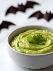 Festive green dip with bat decorations. A simple yet fun snack for Halloween parties. Perfect for healthy and spooky celebrations!