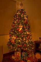 Pine tree as a Christmas decoration with festive decorations and multicolored lights, close-up.
