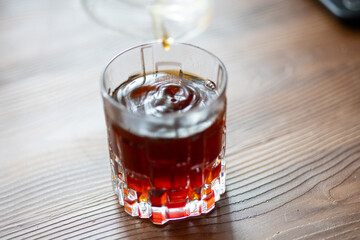 Pouring Filter Coffee into a Crystal Glass in Close-Up
