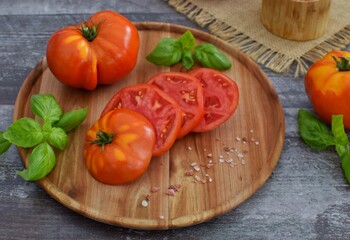 Fresh, juicy sliced ​​tomato with basil and Himalayan salt