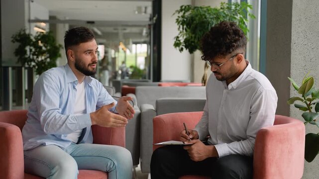 Patient explaining problems to attentive psychiatrist taking notes