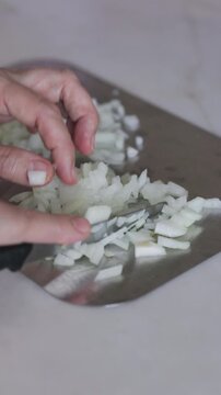 Chopping Onions with a Knife on a Metal Cutting Board