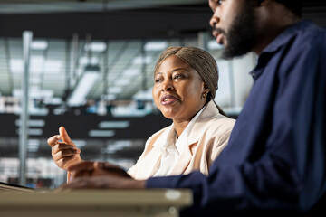 African american business staff studying online data for a presentation, working together on a new...