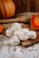 Fototapeta premium Homemade marshmallow dessert with pumpkin on wooden board and rustic background