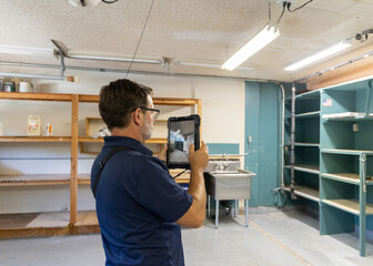 a home inspector taking a photograph of interior of a garage