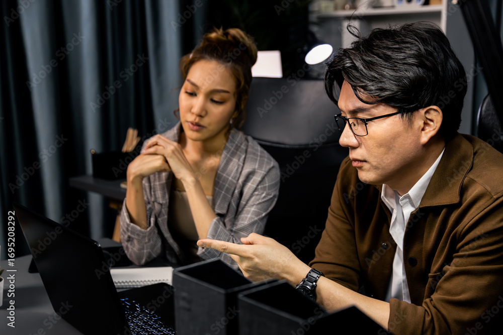 Aufkleber serious face of working sales manager pointing to missing report data analysis on laptop with cowork