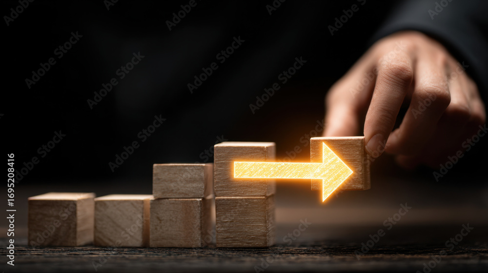 Poster Building blocks are arranged in progressive manner, with hand placing block to symbolize growth and direction. glowing arrow indicates movement towards success and advancement