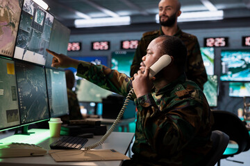 Air force combat control officer performing tactical level surveillance, making telephone call....