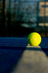 Single yellow tennis ball on the line of a blue court, Sports Equipment
