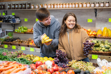 Happy married couple buying various fruits in a grocery supermarket