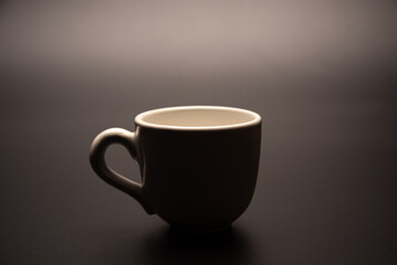 Cup, beautiful cup alone placed on a dark background, selective focus.