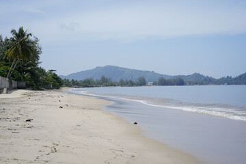 serene tropical beach with gentle waves and scenery on a sunny day